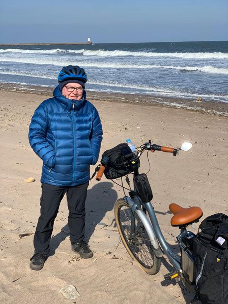 Image of rider standing next to Juicy Classic ebike on the beach